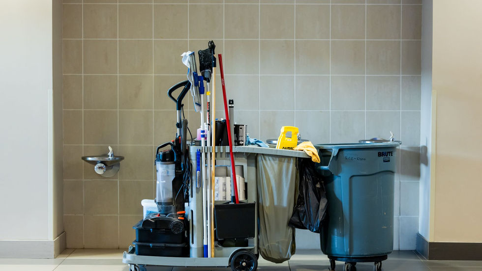Professional office cleaner wiping a desk in a bright Toronto office, representing commercial office cleaning services.