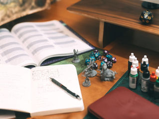 Game notes, minis, paints, dice, and other TTRPG accessories.
