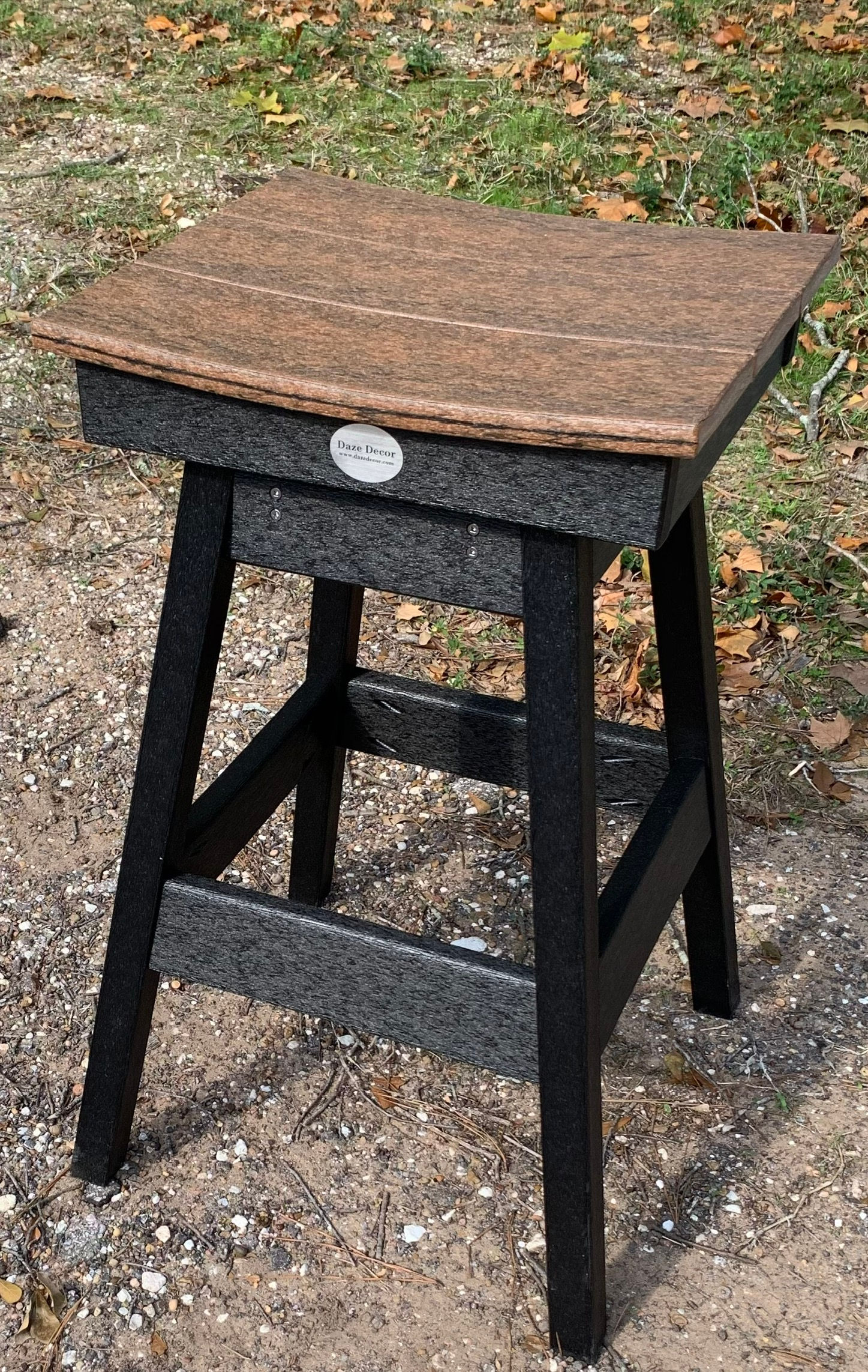 Outdoor bar stool with a brown seat and black legs, brand logo visible.