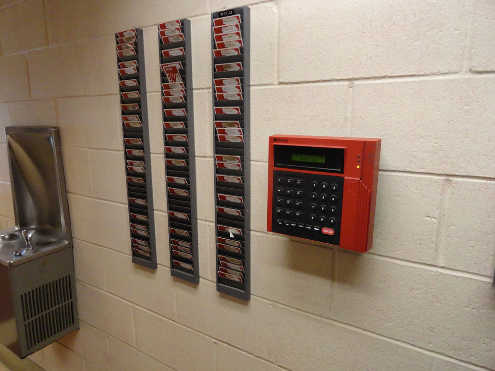 A computerized workplace time clock photographed July 14, 2011. Archival illustration of recording hours worked, not evidence of current wages. Photo: Kevin Rutherford (Ktr101). Image unmodified.
