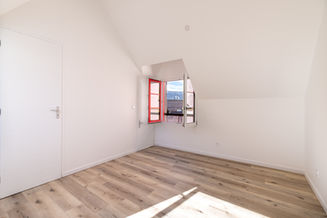 Chambre lumineuse avec fenêtre rouge et sol clair