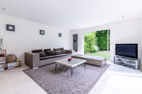 Salon moderne, canapé brun, vue sur jardin 