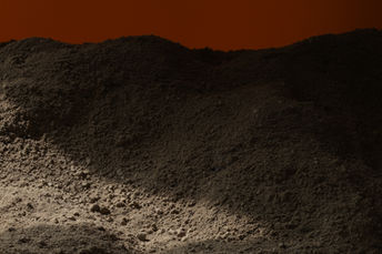 Ein Haufen feiner Vulkangesteine mit einem rot glühenden Hintergrund