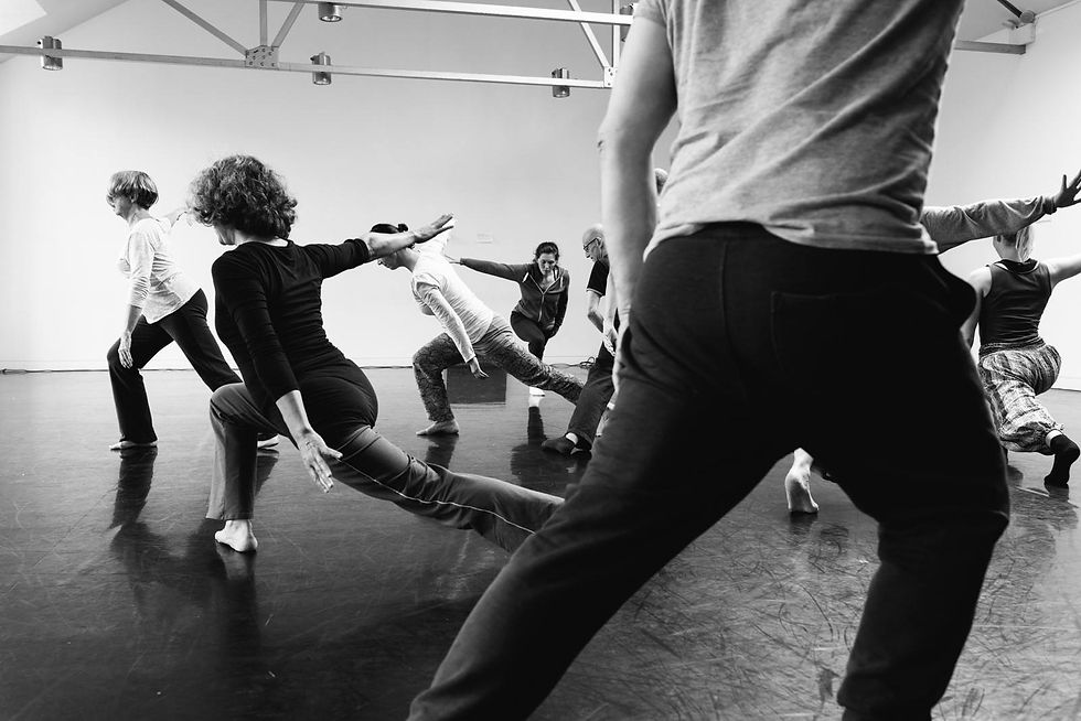 A group of people are dancing in a studio. The photo is in black and white. 