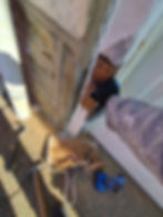 Worker repairing exterior trim for painting projects.