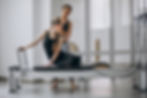 woman-with-pilates-trainer-practising-pilates.jpg
