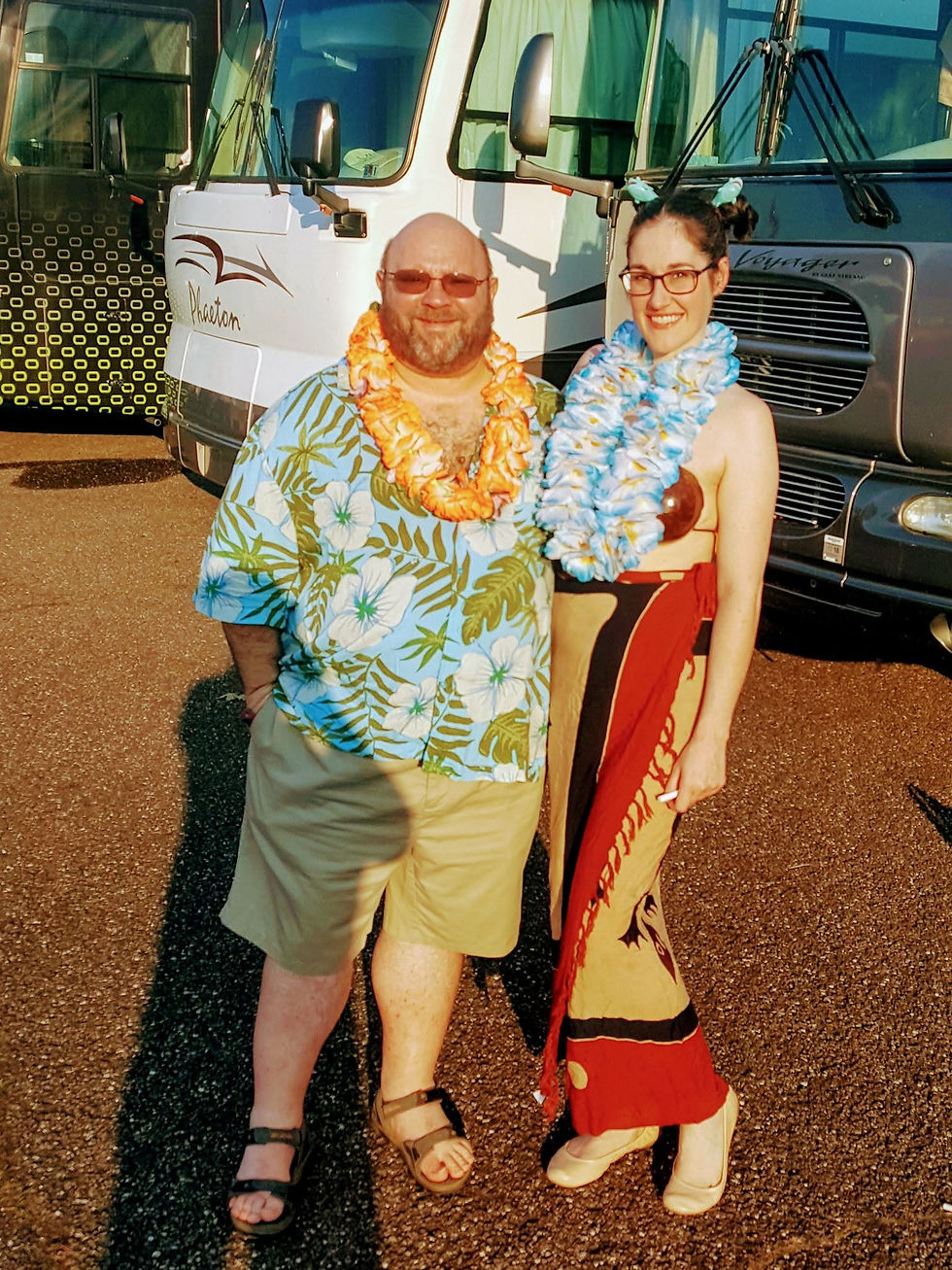 Alan and Gail pose near RVs and tailgating Parrotheads before a Jimmy Buffett concert at Riverbend.