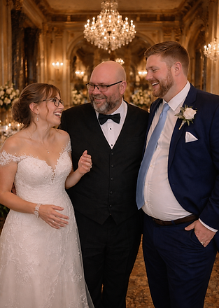 Wedding DJ Alan Mostov laughing with a bride and groom inside an elegant ballroom wedding reception.