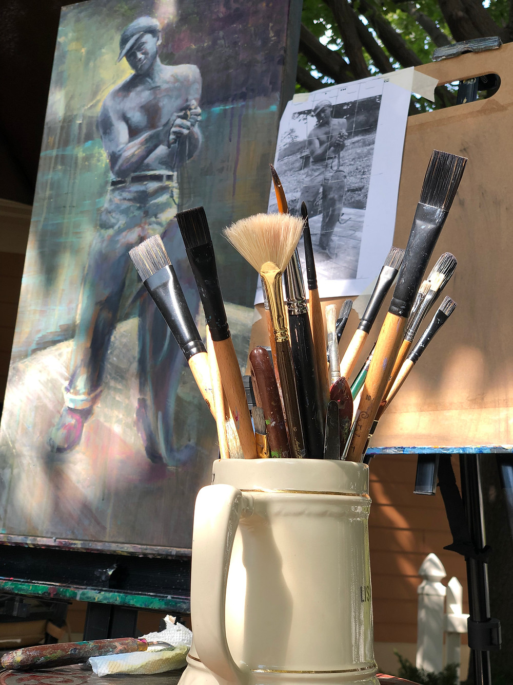 painting and paintbrushes in dappled sunlight