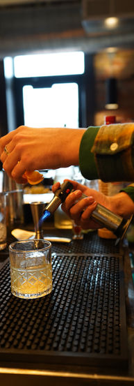 bartender lighting a garnish for a cocktail