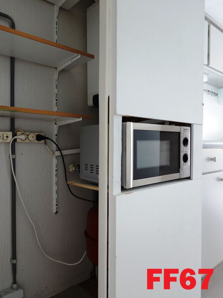 Thumbnail: Interior da cozinha com micro-ondas embutido e armário branco