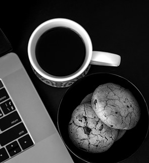 A cup of coffee and some cookies on a de