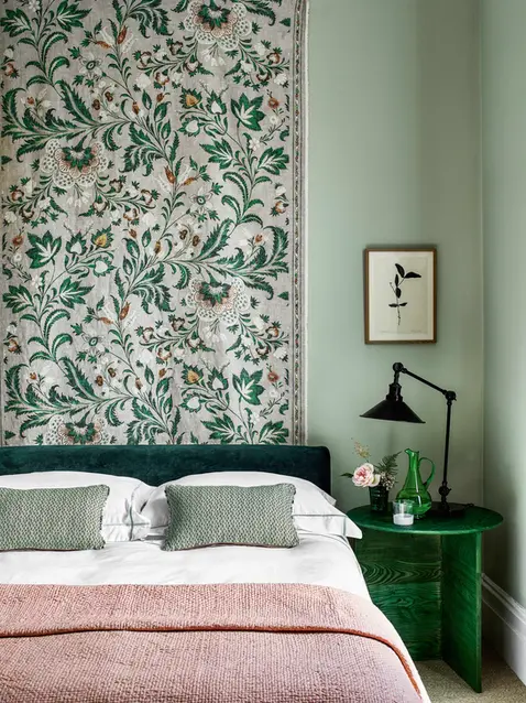Pale green bedroom with green furniture and pink sheets