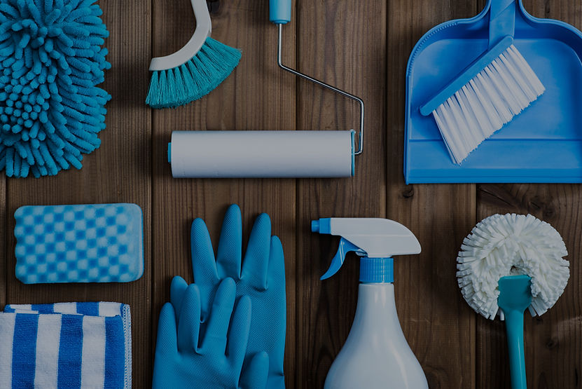 Cleaning supplies arranged on wood surface: brush, gloves, spray bottle, and Cloud Cleaning Services.