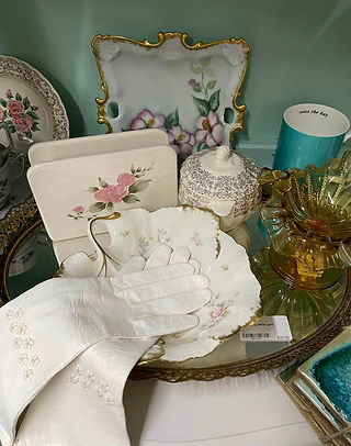 Antique dressing gloves on mirrored tray with glassware