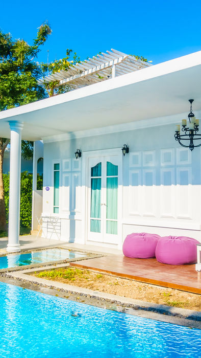 Modern white villa with private pool and patio lounge.