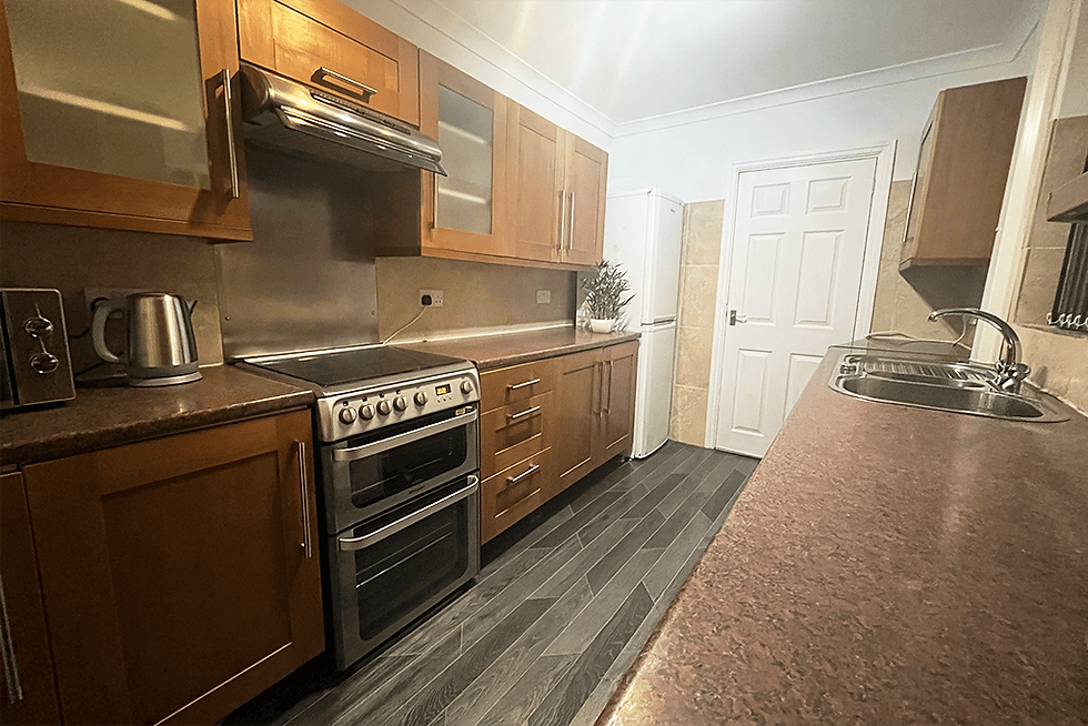 Spacious kitchen with brown cupboards in student house