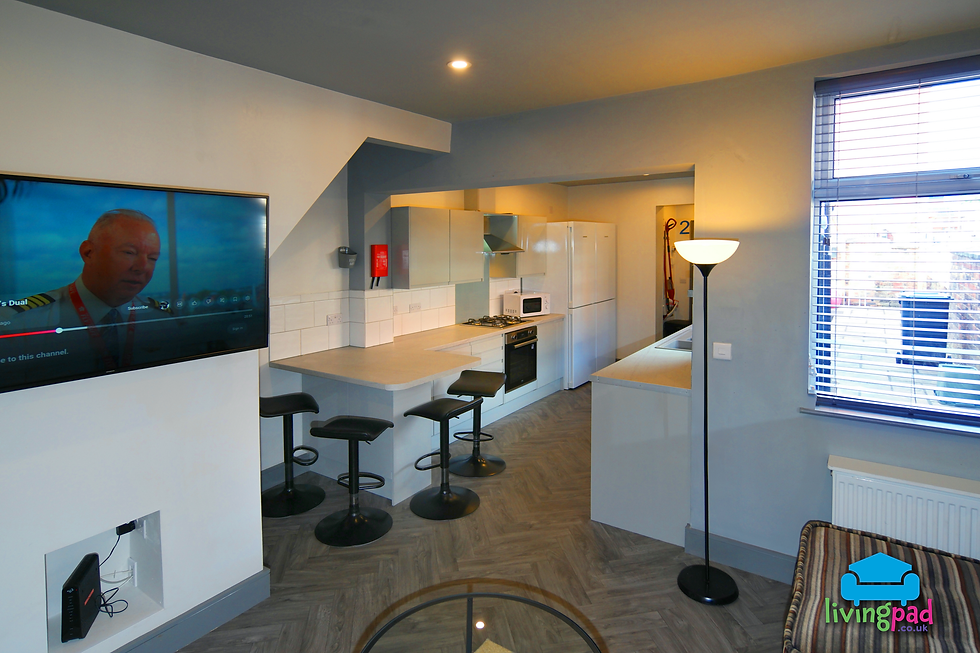 Large student kitchen with wall-mounted grey cupboards and black oven