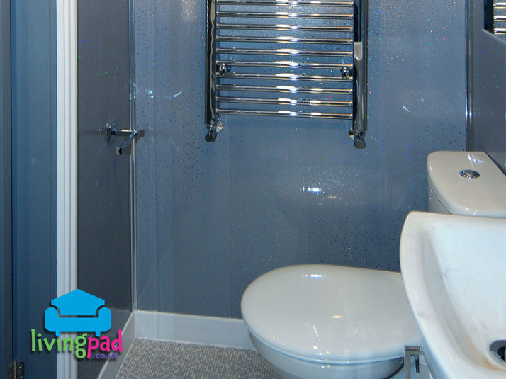 Bright and modern en-suite bathroom in a 5-bedroom student property, with grey panelling and a silver wall-mounted towel radiator