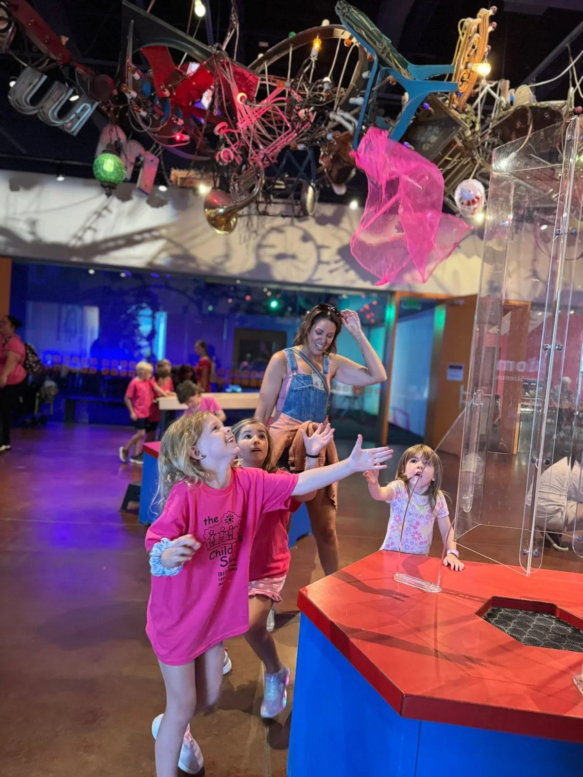 Children exploring floating fabric at a science museum on a school field trip in July 2025