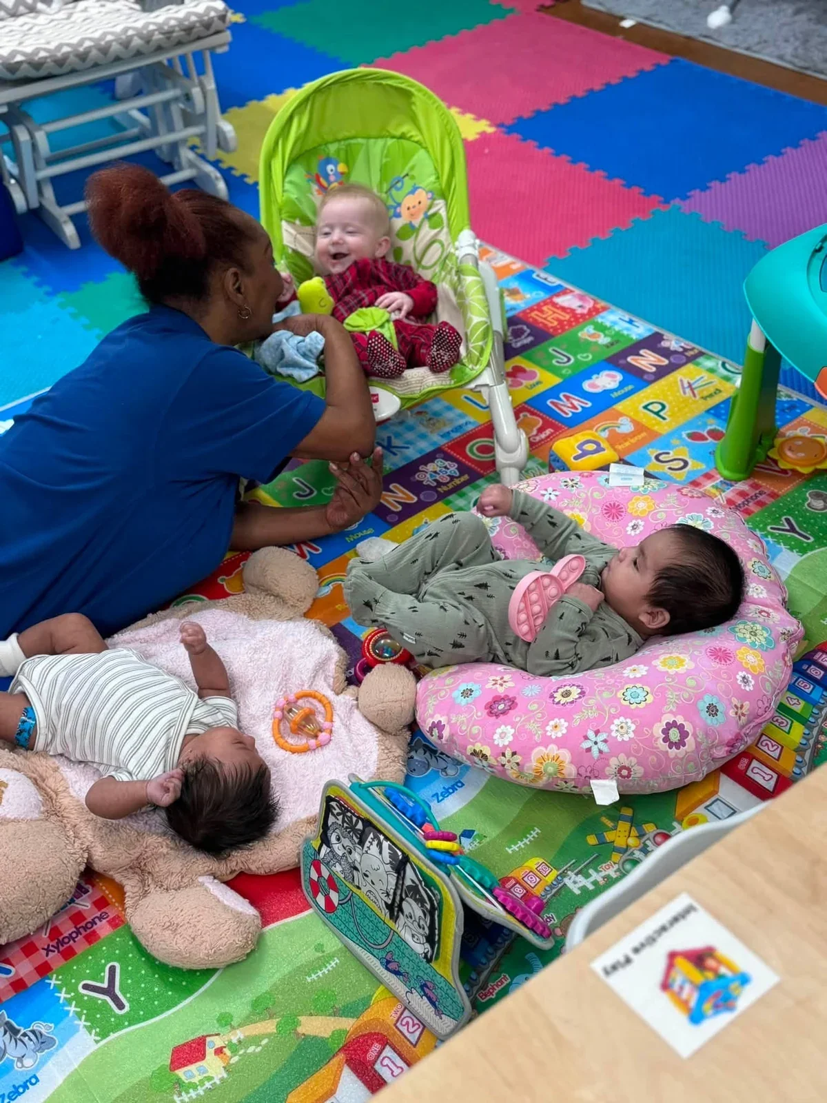 A teacher connecting with babies during floor play in the infant classroom in August 2026