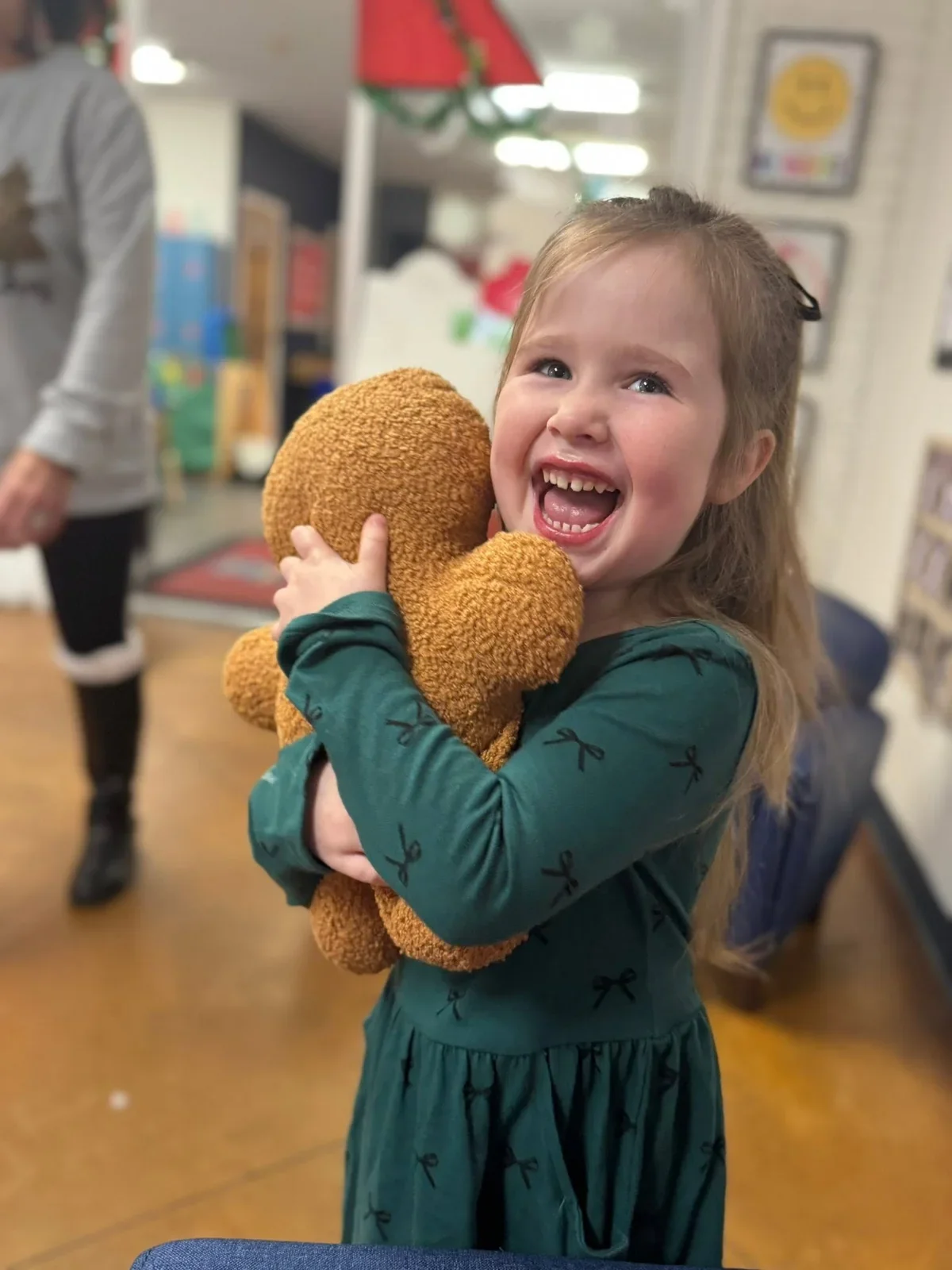 A laughing child with a gingerbread toy at the school’s Breakfast with Santa in December 2025