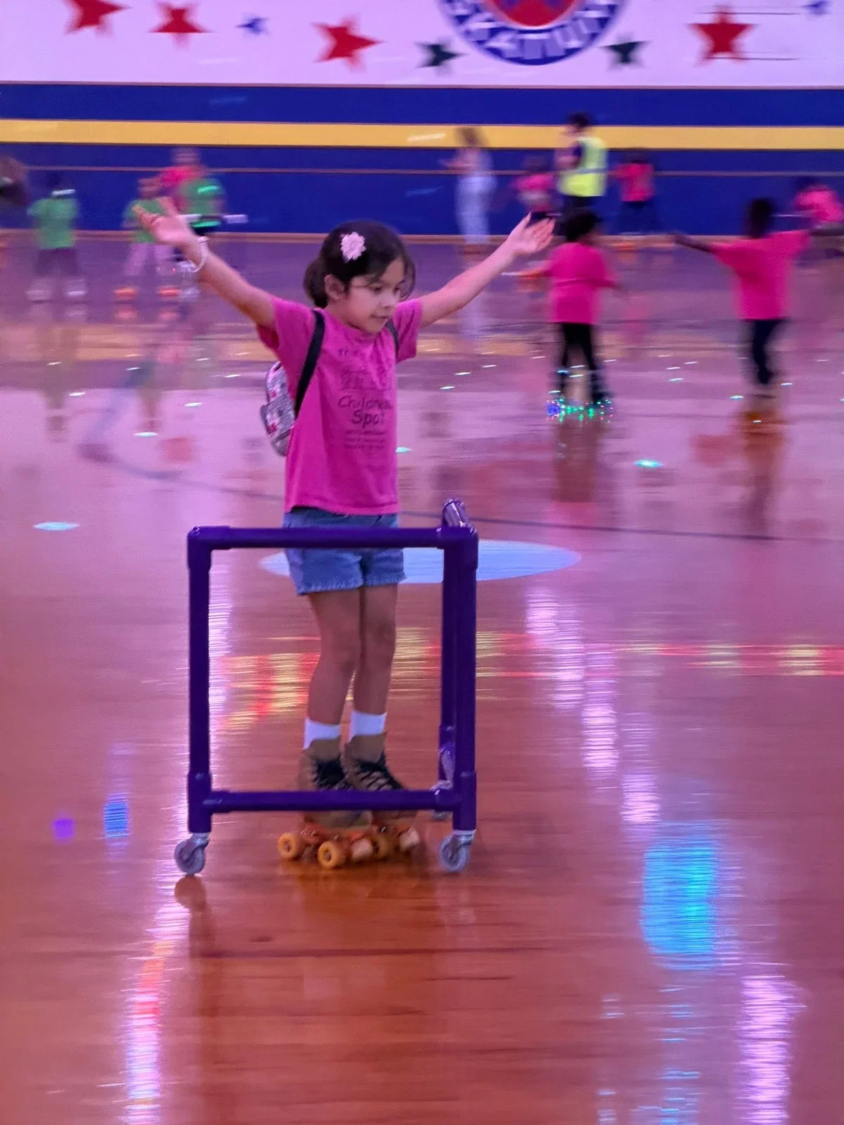 A child raising both arms with joy on a school roller skating outing in July 2026