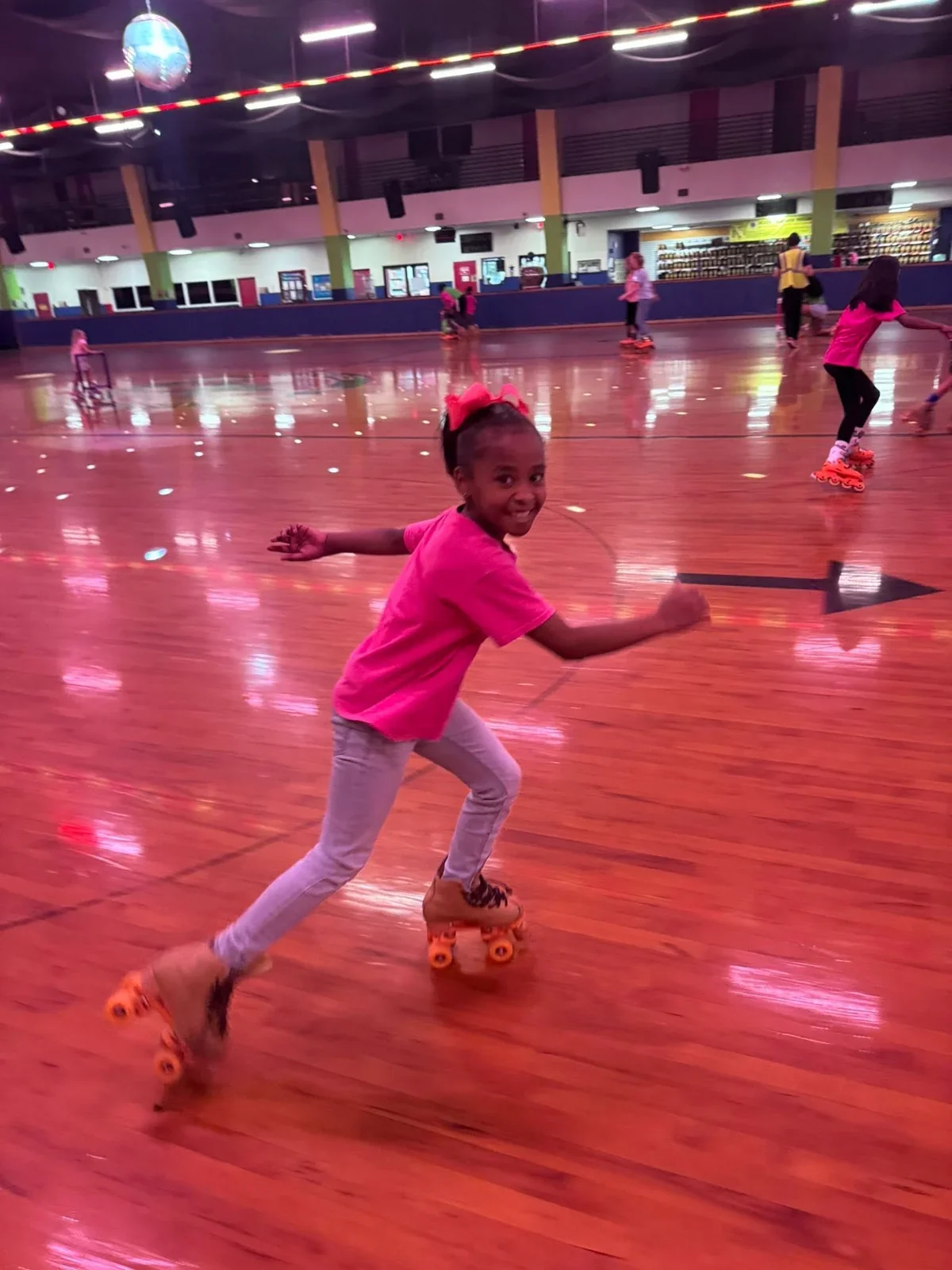 A child roller skating at a rink on a school outing