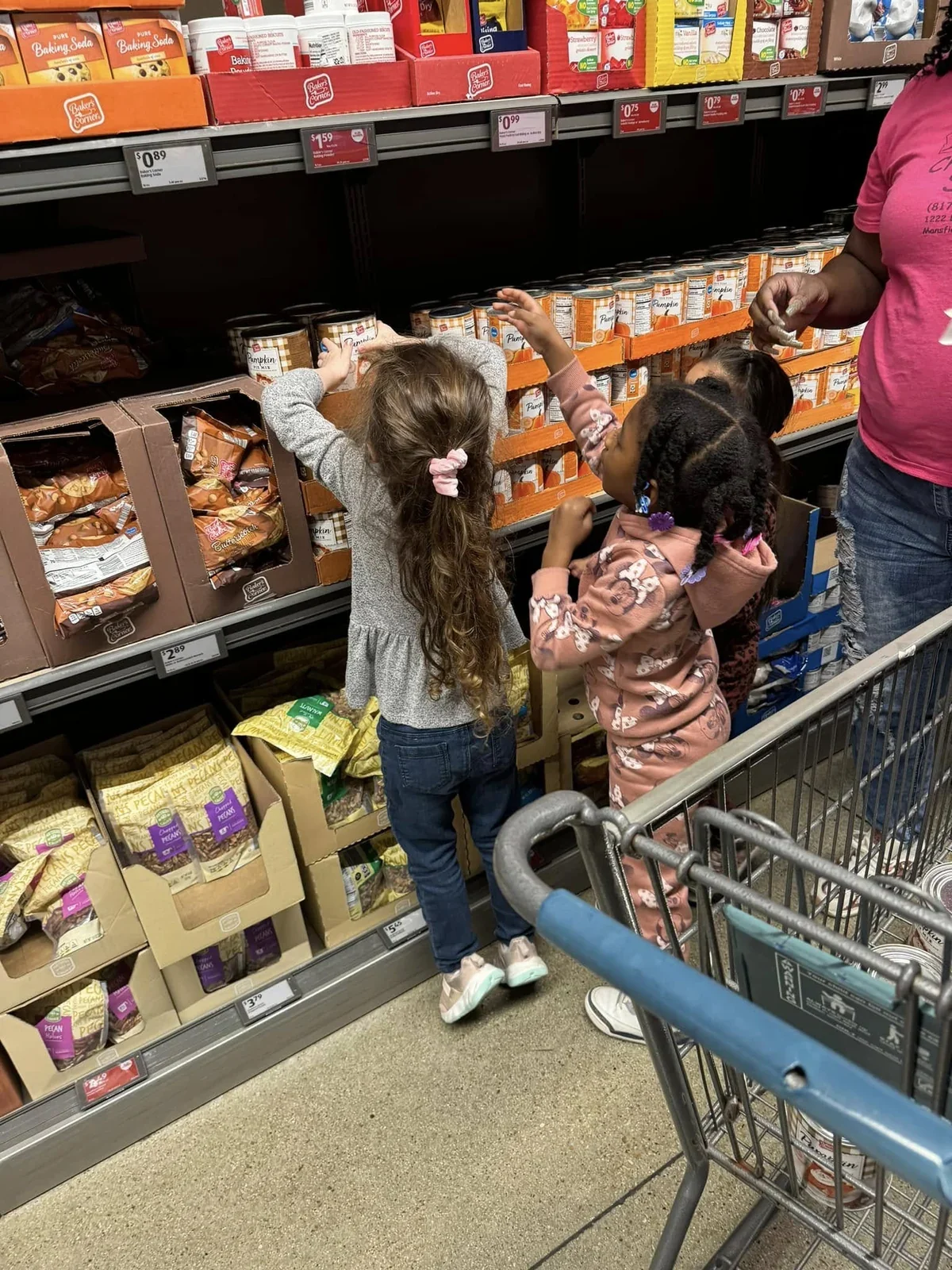 Kinder-Prep children choosing canned food from the shelves at ALDI for Thanksgiving donations