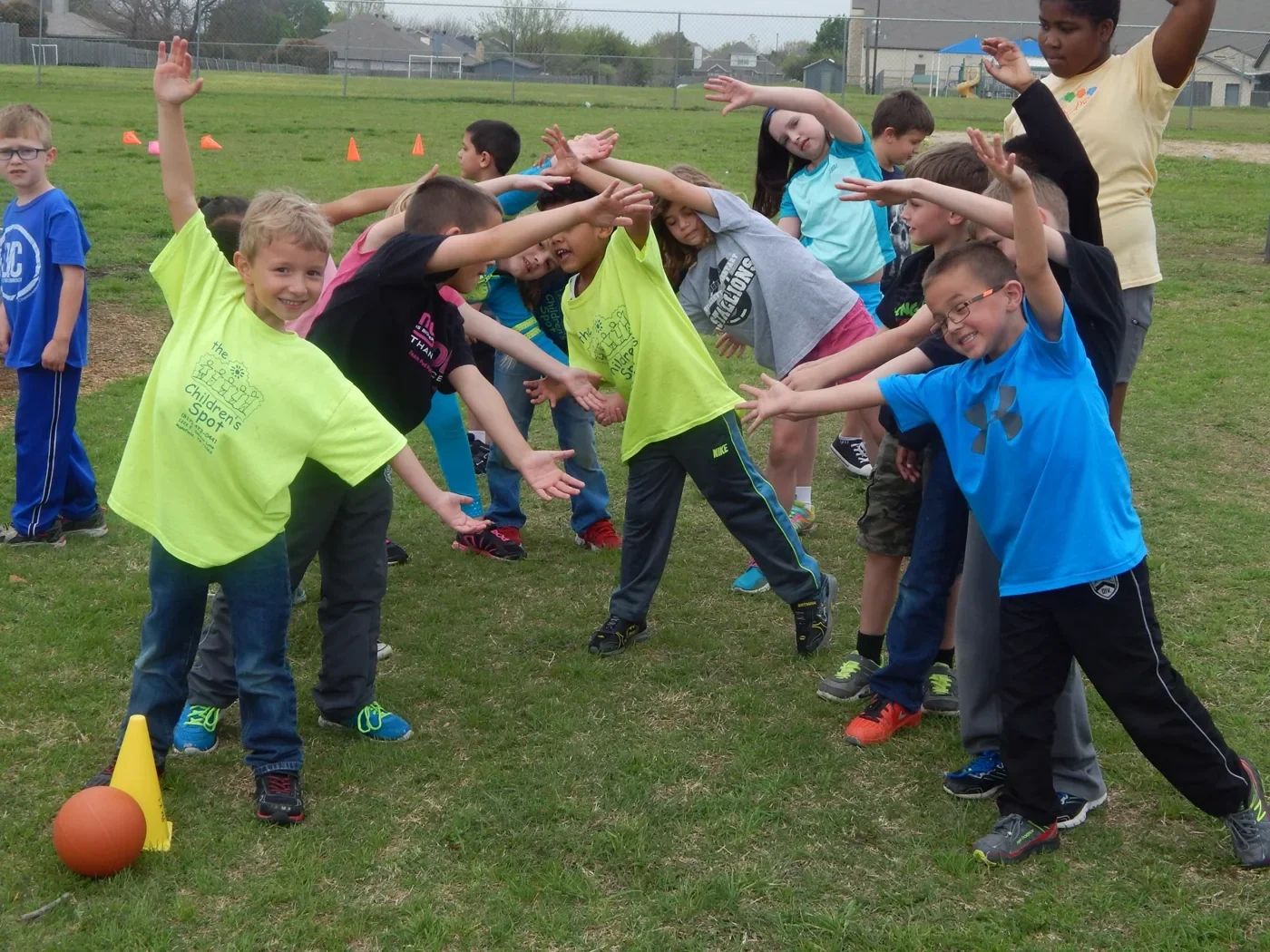 Children moving and playing together on the school’s grassy outdoor campus