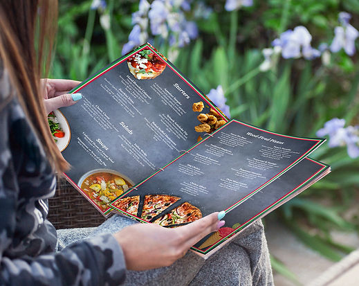 A mockup of the Pasta Amoré menu - a woman holding the menu open and reading it