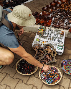 A traveler looking through some locally crafted bracelets from a vendor in the village of Victoria Falls