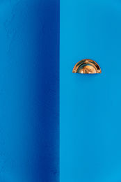 Détail de décoration murale bleu et laiton dans un intérieur contemporain, idéal pour la location saisonnière