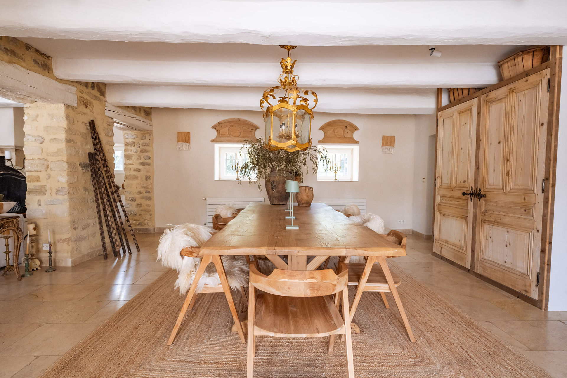 Salle à manger d’un mas provençal rénové avec grande table en bois et lustre doré, décor authentique en Provence.