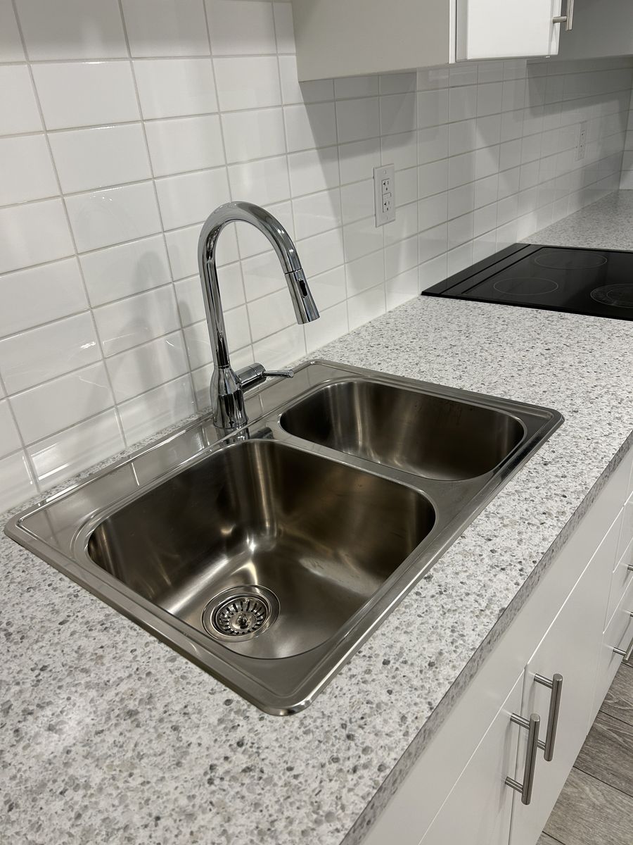 A stainless steel kitchen sink, shining