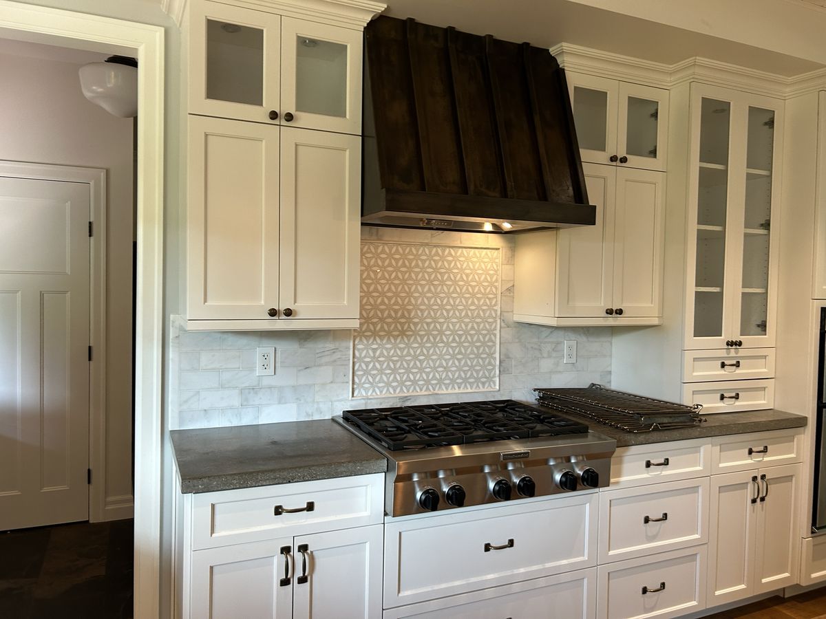A white kitchen with a gas cooktop, cleaned by K.Cleaners