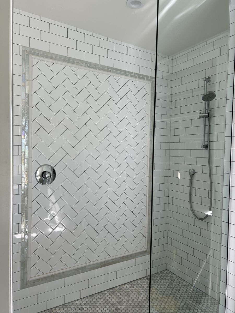 A white tiled shower with clear glass