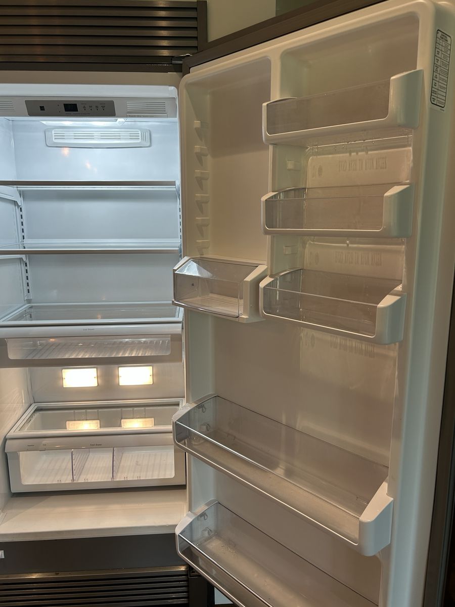 The inside of a fridge, emptied and cleaned