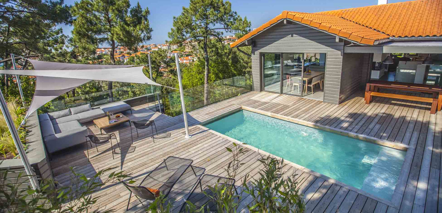 back yard pool with a sitting area and a sun shade