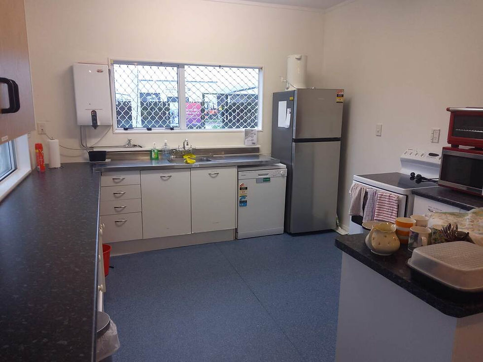 Equipped kitchen with sink, fridge, and counters in a clubhouse