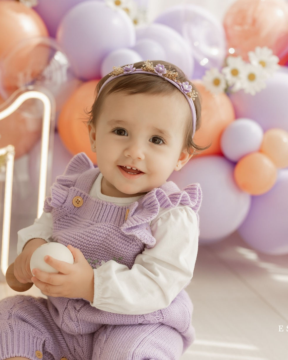 Retrato infantil de Ester com roupa lilás e flores