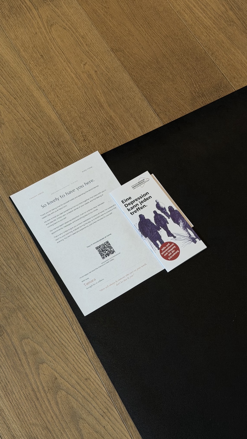 Persönlicher Brief mit QR-Code zur Meditation neben Informationsmaterial der Deutschen Depressionshilfe auf einer Matte
