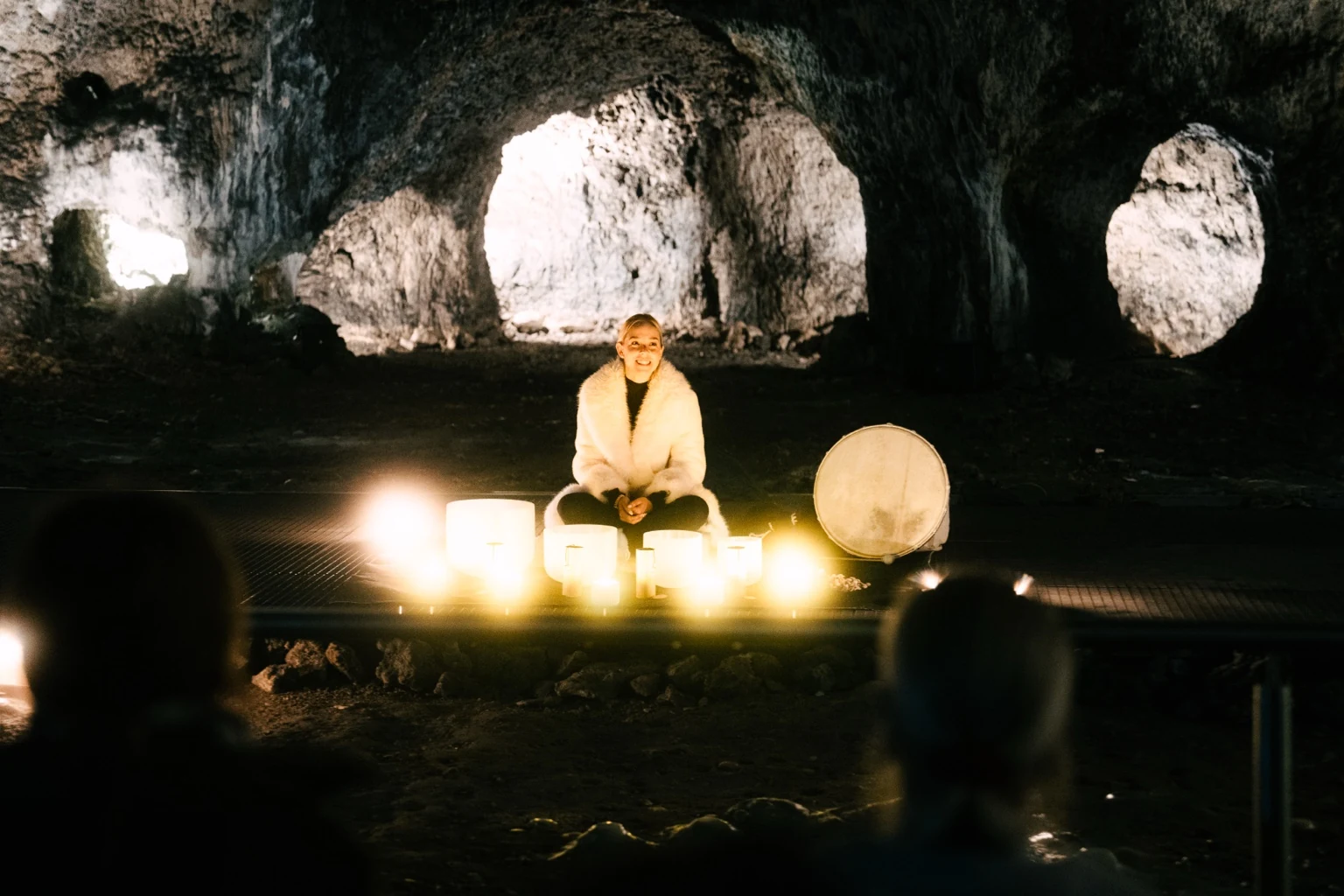 Tamara Hibler mit leuchtenden Kristallklangschalen in der Tropfsteinhöhle Schulerloch.
