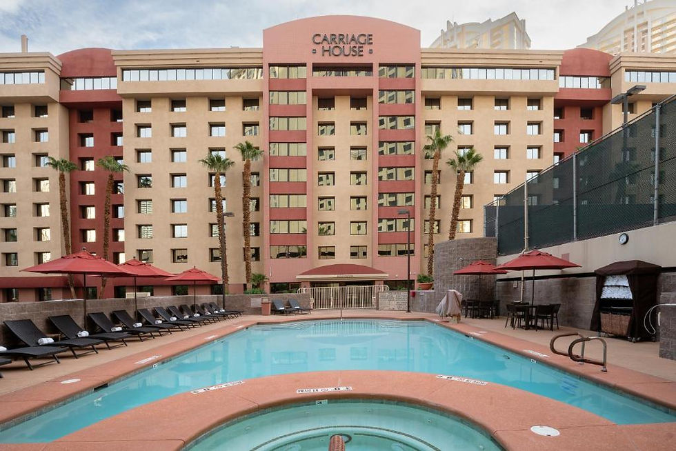 Hotel pool area with red loungers and umbrellas, set before a beige and red building labeled "Carriage House." Palm trees line the scene.