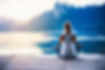 Young woman meditating by the lake.jpg