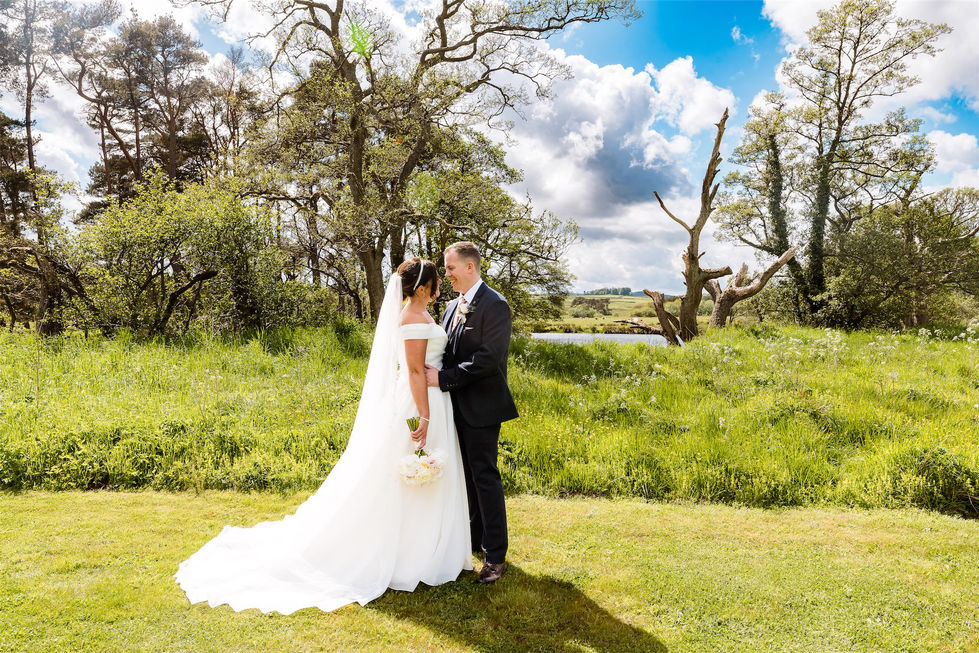 a bride and groom are posing for a picture in a field