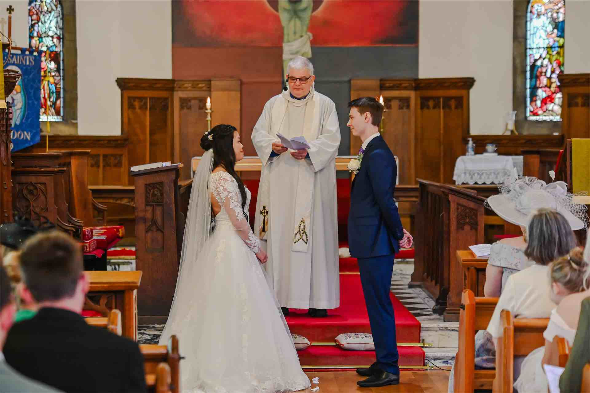 Bride and groom exchanging vows during church ceremony wedding photographers in the north east