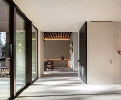 Maison moderne avec un sol en pierre naturelle de travertin qui relie harmonieusement l'intérieur et l'extérieur.