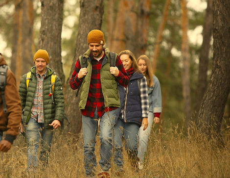 A joyful group hiking in the forest – Contact Dynamo Ohjelmapalvelut