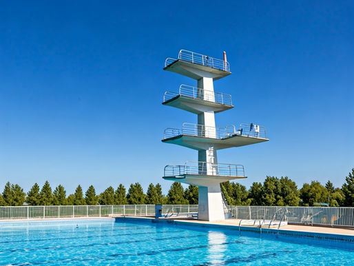 Hoher Sprungturm über einem Freibadbecken bei blauem Himmel – Sinnbild für Annikas Angst vor dem Schritt in die Selbstständigkeit.